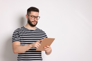 Photo of Handsome man using tablet on white background, space for text