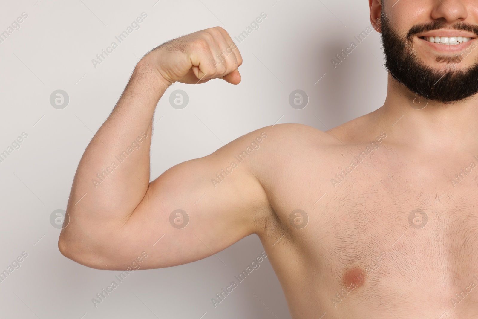 Man showing his bicep on light background, closeup Photo of Man showing his bicep on light background, closeup