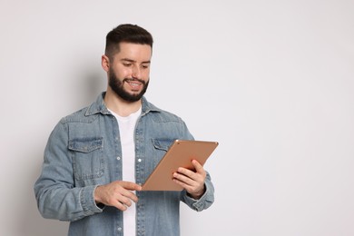 Photo of Handsome man using tablet on white background, space for text