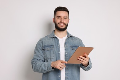 Photo of Handsome man using tablet on white background