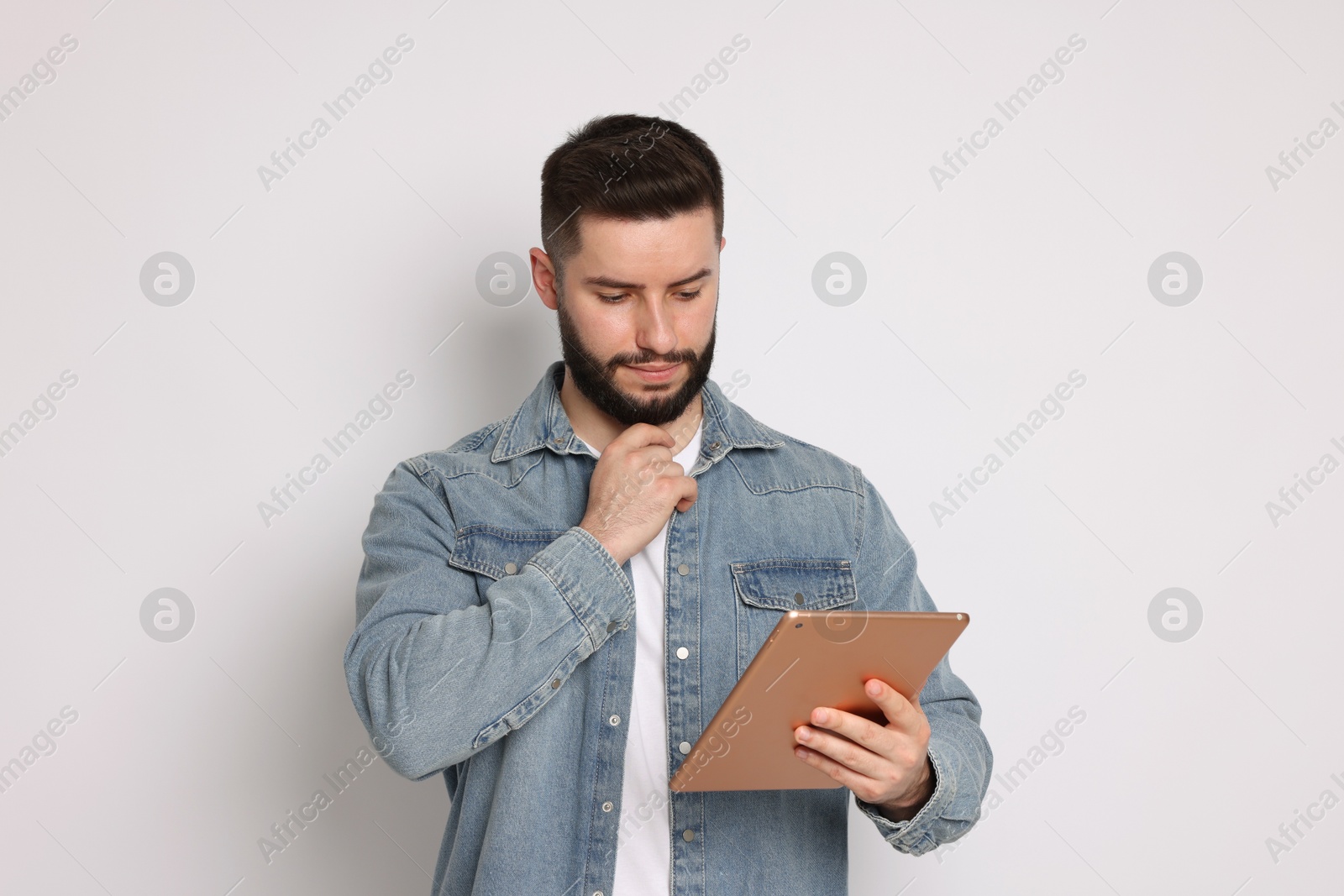 Handsome man using tablet on white background Photo of Handsome man using tablet on white background