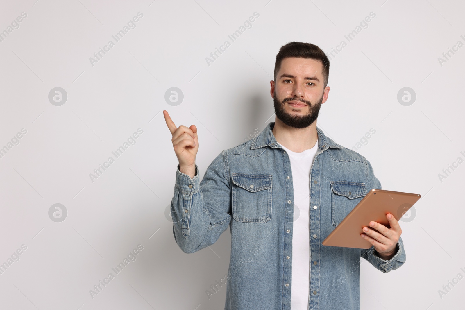 Handsome man using tablet on white background, space for text Photo of Handsome man using tablet on white background, space for text
