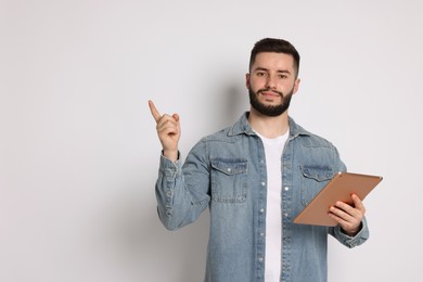 Photo of Handsome man using tablet on white background, space for text