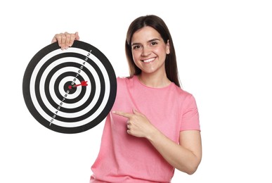 Photo of Targeting. Smiling woman pointing at dart board with arrow on white background