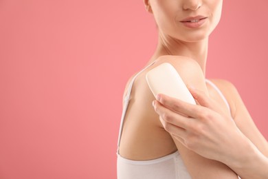 Photo of Woman with soap bar on pink background, closeup. Space for text