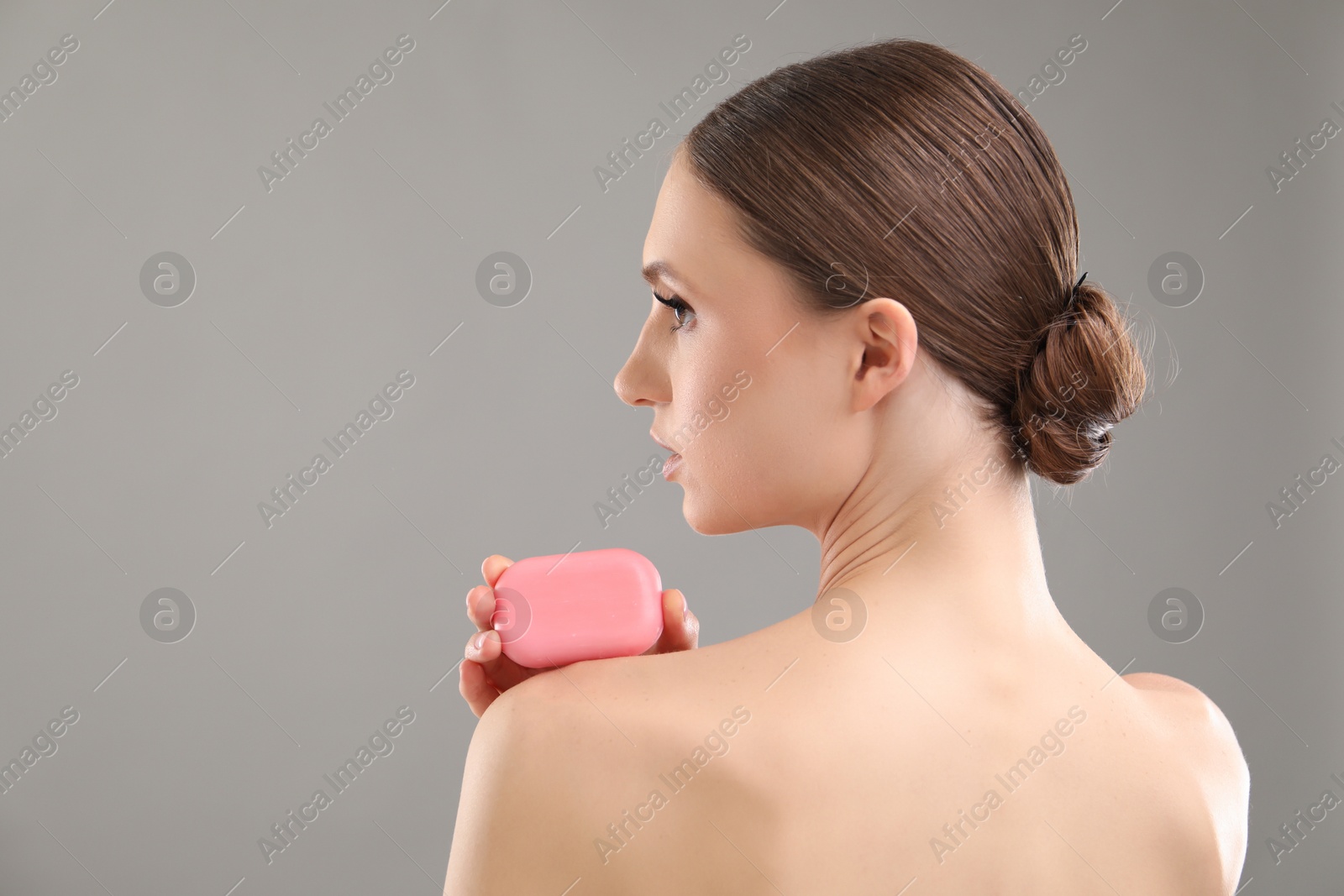 Beautiful woman with soap bar on grey background. Space for text Photo of Beautiful woman with soap bar on grey background. Space for text