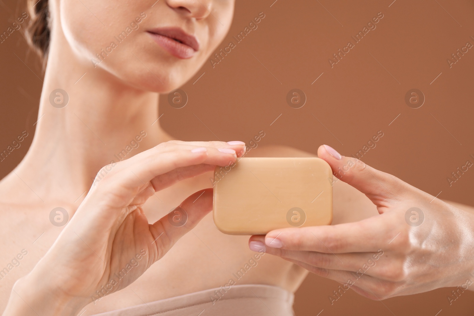 Woman with soap bar on brown background, closeup Photo of Woman with soap bar on brown background, closeup