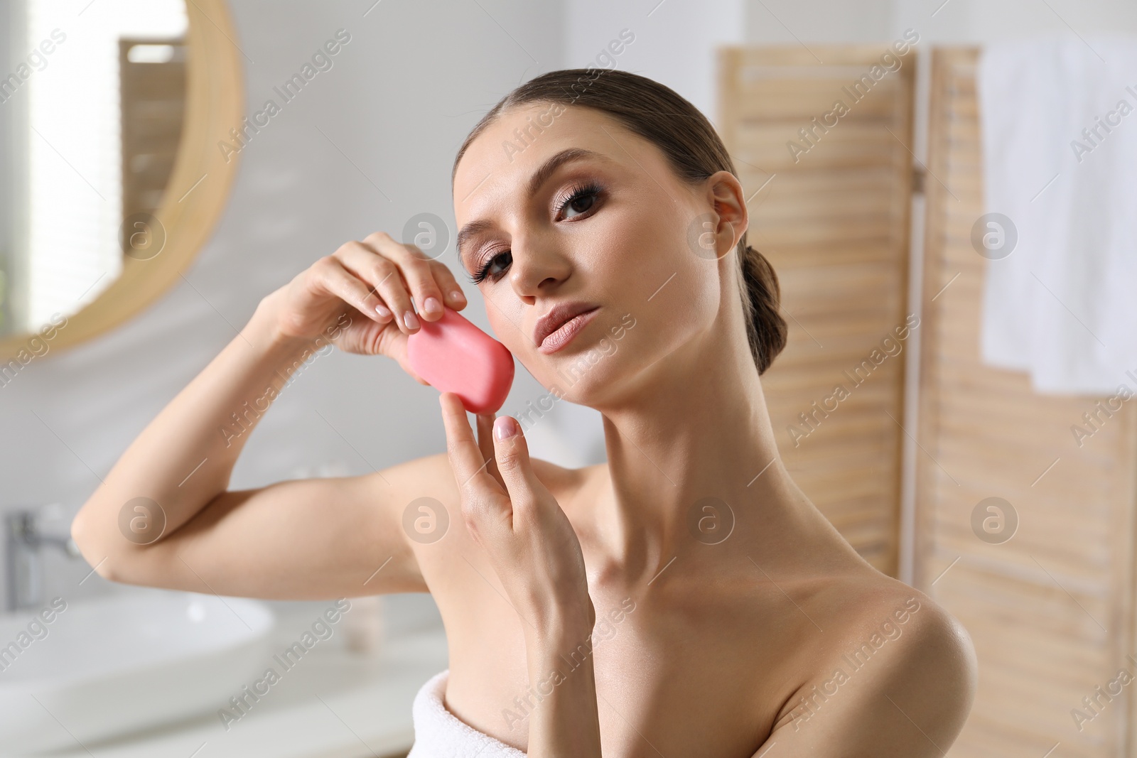 Beautiful woman with soap bar in bathroom, closeup Photo of Beautiful woman with soap bar in bathroom, closeup
