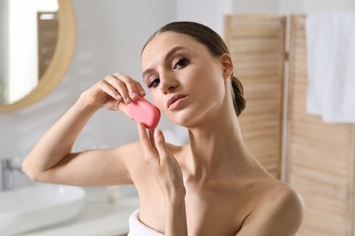 Photo of Beautiful woman with soap bar in bathroom, closeup