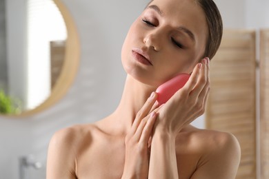 Photo of Beautiful woman with soap bar in bathroom, closeup