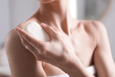 Photo of Woman with soap bar in bathroom, closeup