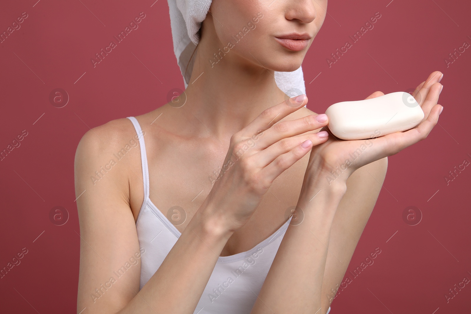 Photo of Woman with soap bar on pink background, closeup