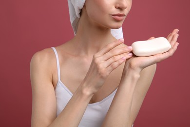 Photo of Woman with soap bar on pink background, closeup