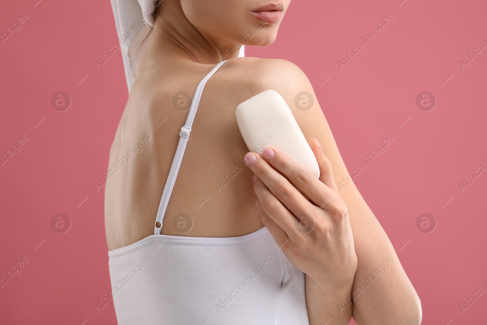Photo of Woman with soap bar on pink background, closeup