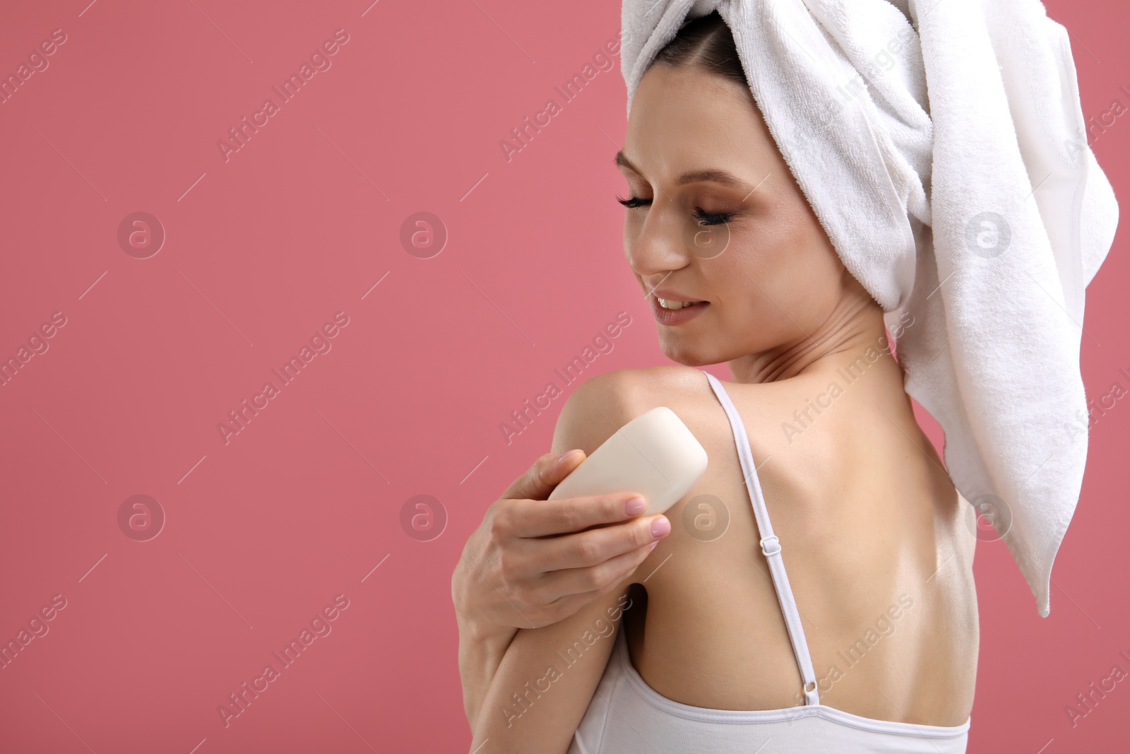Smiling woman with soap bar on pink background. Space for text Photo of Smiling woman with soap bar on pink background. Space for text