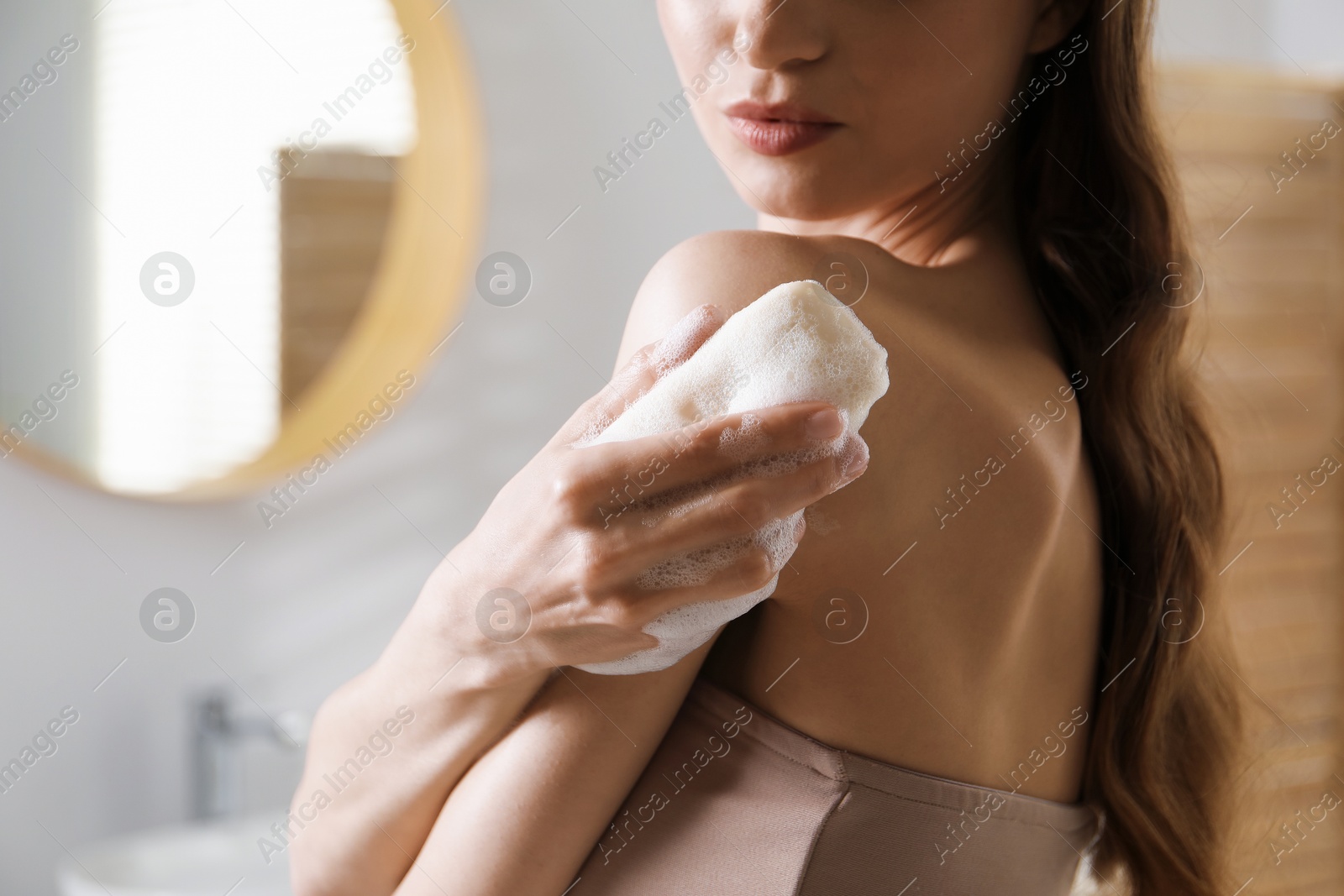 Photo of Woman washing body with soap bar in bathroom, closeup