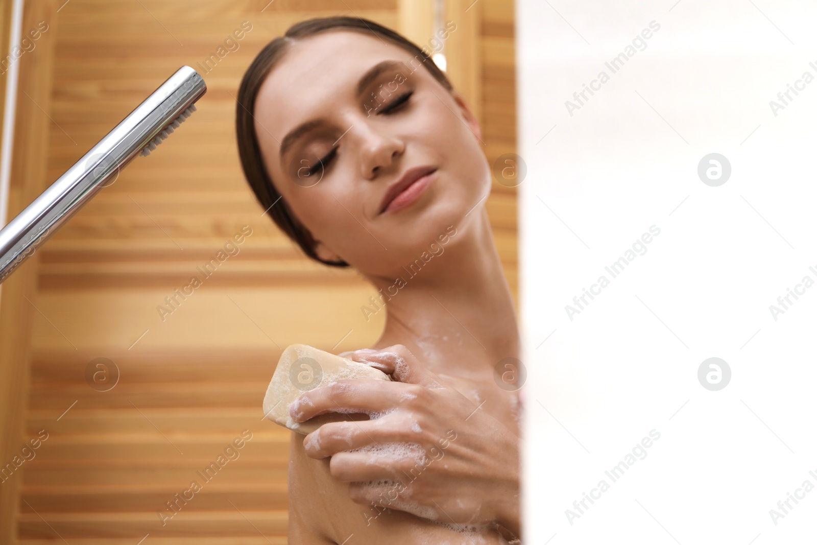 Woman washing body with soap bar indoors. Space for text Photo of Woman washing body with soap bar indoors. Space for text