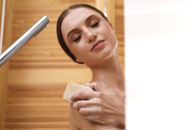 Photo of Woman washing body with soap bar indoors. Space for text