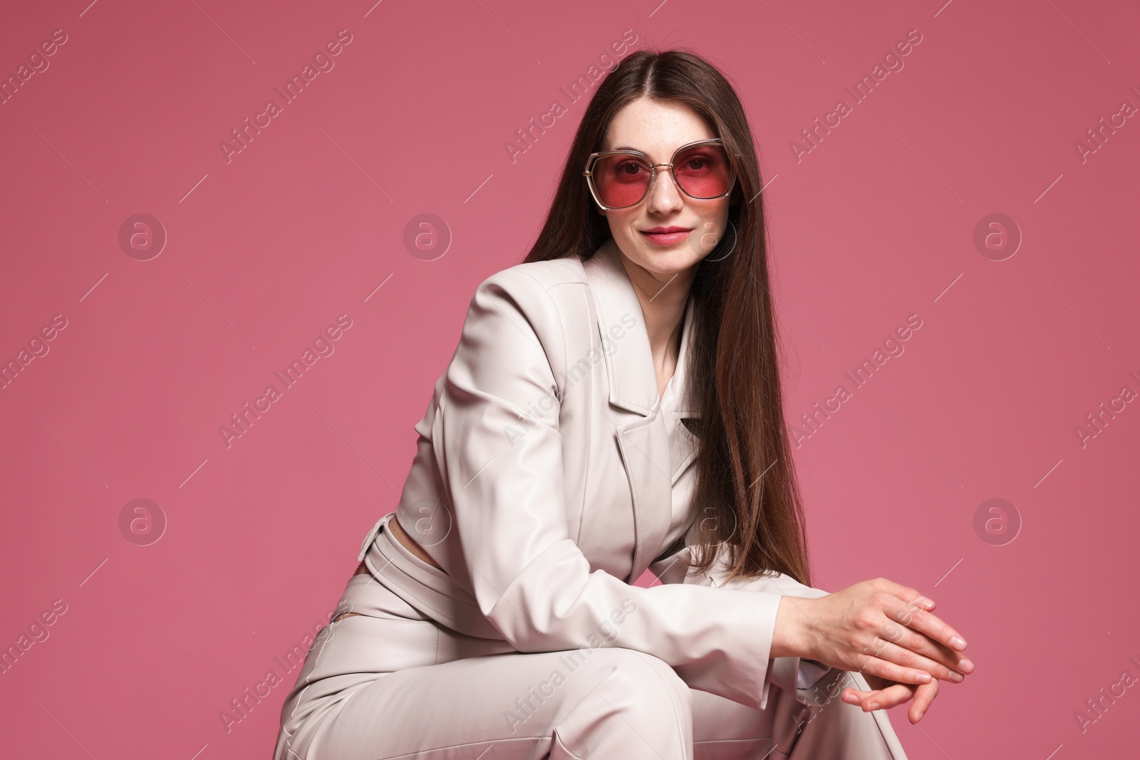 Fashionable portrait of beautiful woman in stylish outfit on pink background Photo of Fashionable portrait of beautiful woman in stylish outfit on pink background