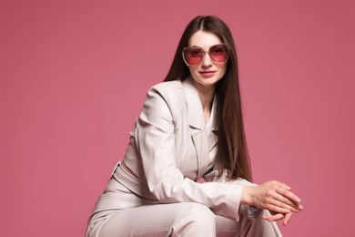 Photo of Fashionable portrait of beautiful woman in stylish outfit on pink background