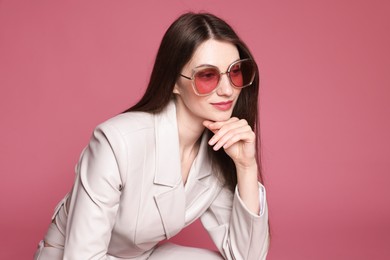 Photo of Fashionable portrait of beautiful woman in stylish outfit on pink background