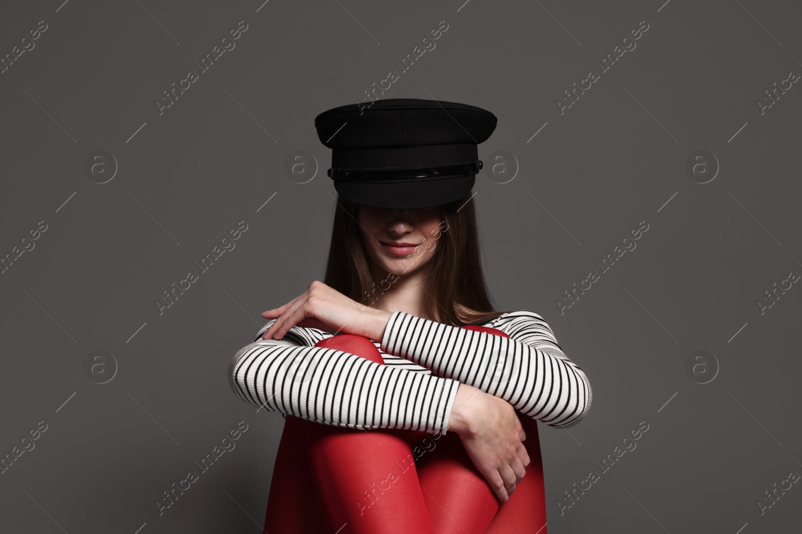 Fashionable portrait of beautiful woman in stylish outfit on grey background Photo of Fashionable portrait of beautiful woman in stylish outfit on grey background