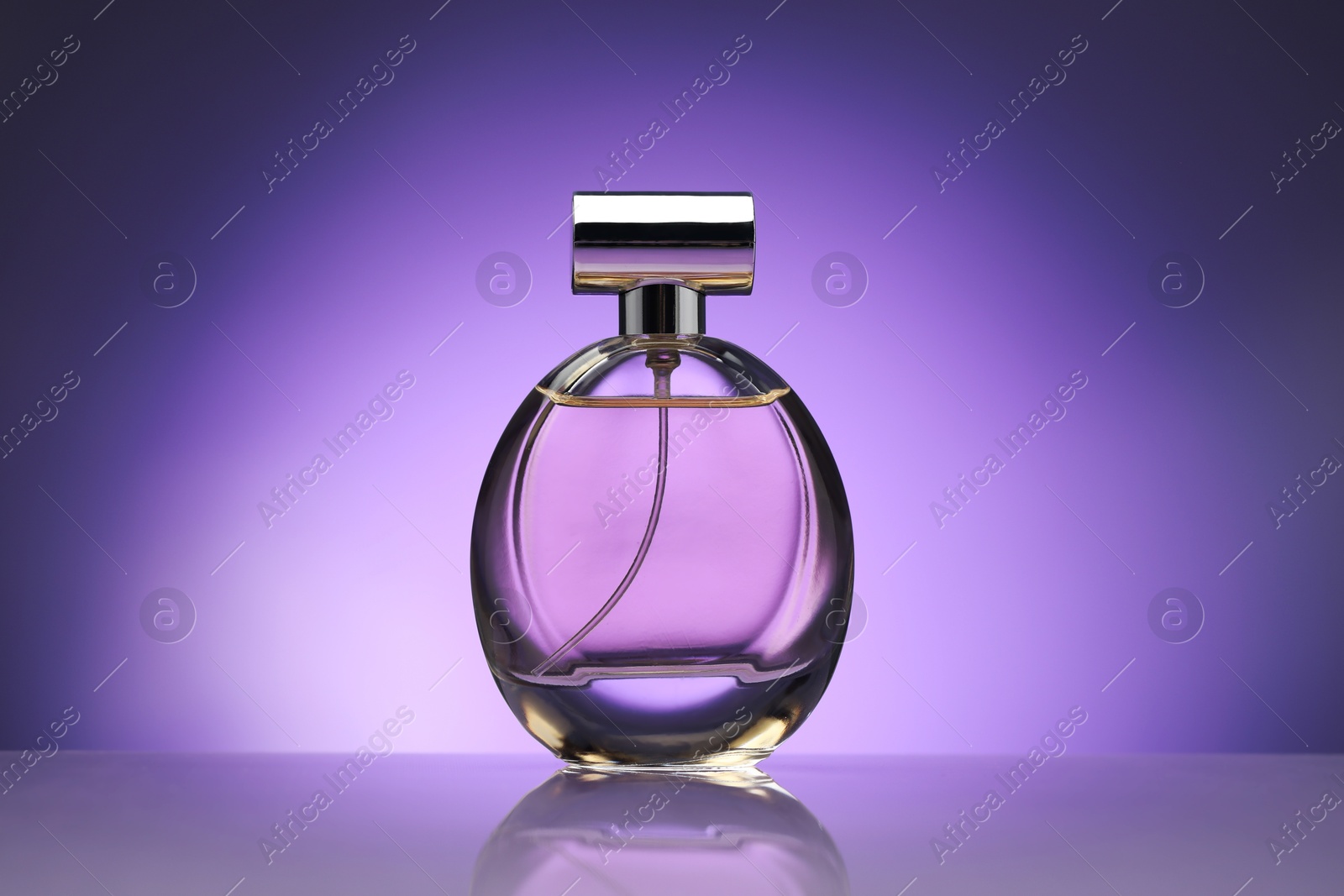 Bottle of perfume on mirror surface against purple gradient background Photo of Bottle of perfume on mirror surface against purple gradient background
