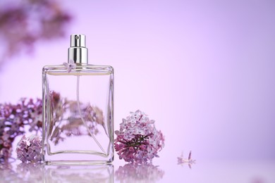 Photo of Bottle of perfume and lilac flowers on mirror surface against violet gradient background, selective focus. Space for text
