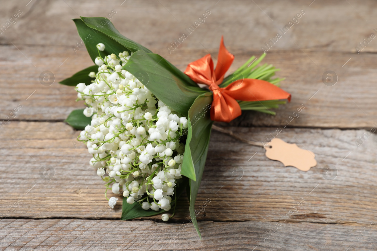 Bouquet of beautiful lily-of-the-valley flowers on wooden background, closeup Photo of Bouquet of beautiful lily-of-the-valley flowers on wooden background, closeup