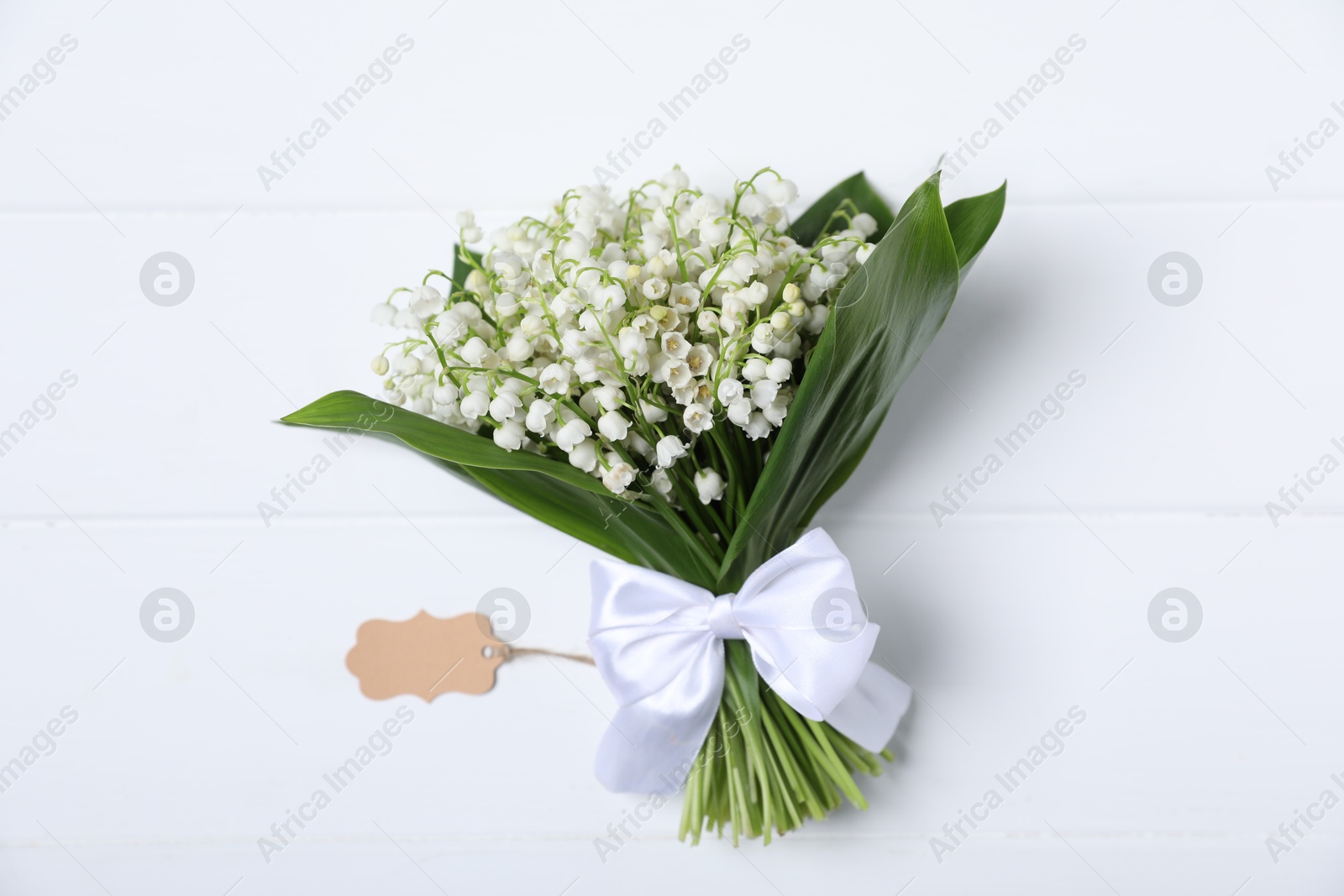Bouquet of beautiful lily-of-the-valley flowers on white wooden background, top view Photo of Bouquet of beautiful lily-of-the-valley flowers on white wooden background, top view