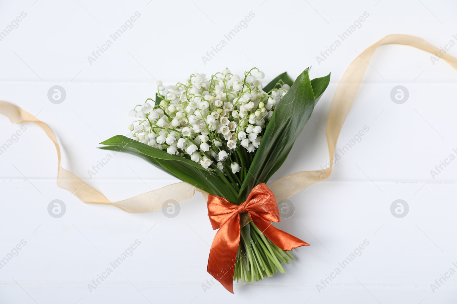 Bouquet of beautiful lily-of-the-valley flowers on white wooden background, top view Photo of Bouquet of beautiful lily-of-the-valley flowers on white wooden background, top view