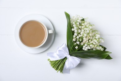 Photo of Bouquet of beautiful lily-of-the-valley flowers and coffee on white wooden background, top view