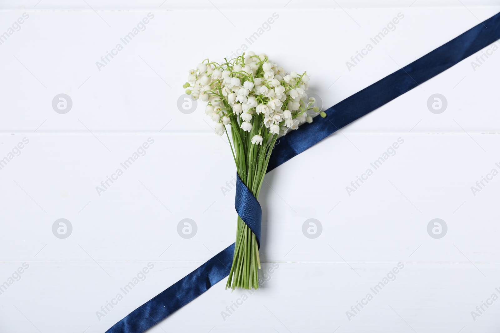 Bouquet of beautiful lily-of-the-valley flowers on white wooden background, top view Photo of Bouquet of beautiful lily-of-the-valley flowers on white wooden background, top view