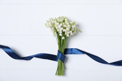 Photo of Bouquet of beautiful lily-of-the-valley flowers on white wooden background, top view