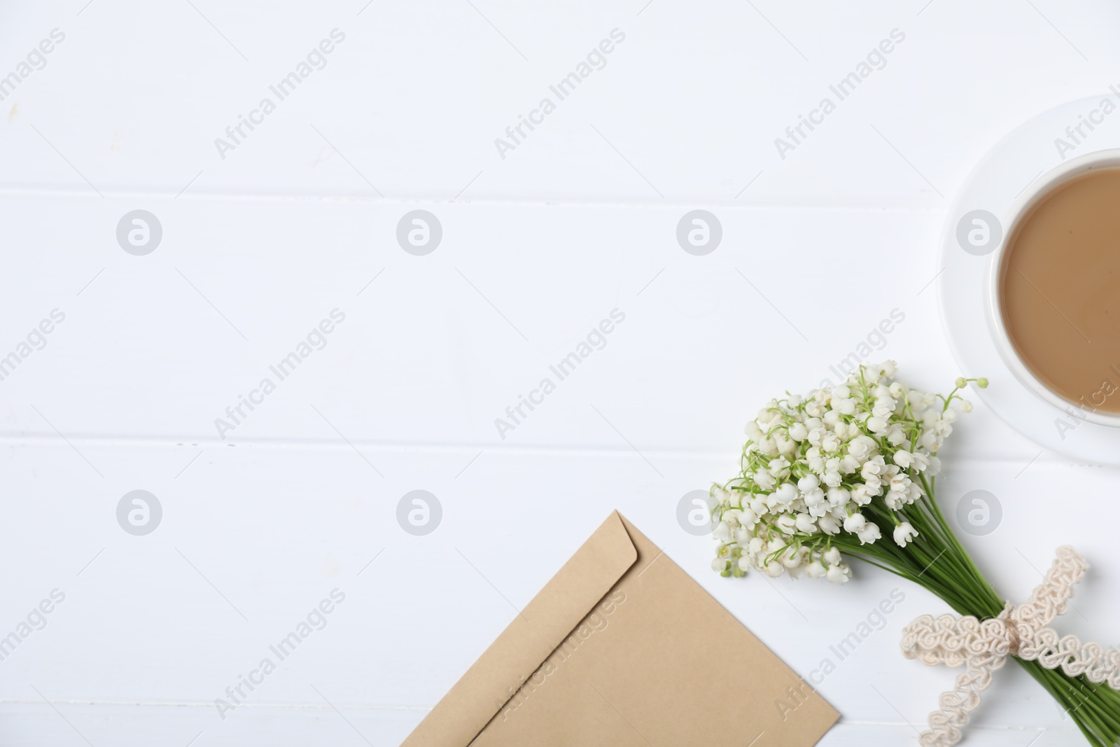 Bouquet of beautiful lily-of-the-valley flowers, coffee and envelope on white wooden background, flat lay. Space for text Photo of Bouquet of beautiful lily-of-the-valley flowers, coffee and envelope on white wooden background, flat lay. Space for text