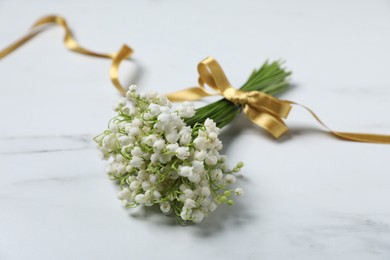 Photo of Bouquet of beautiful lily-of-the-valley flowers on white marble background, closeup