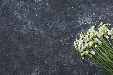 Photo of Beautiful lily-of-the-valley flowers on black textured background, flat lay. Space for text