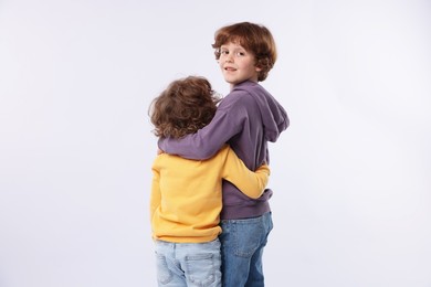 Photo of Cute little brothers hugging on white background