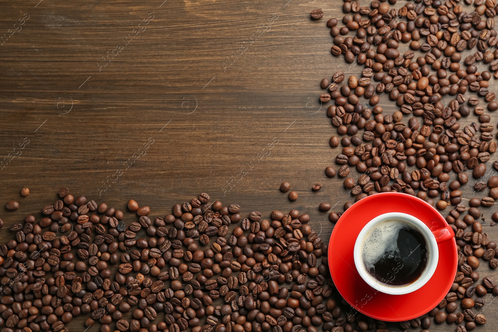 Aromatic coffee in cup and beans on wooden table, flat lay. Space for text Photo of Aromatic coffee in cup and beans on wooden table, flat lay. Space for text