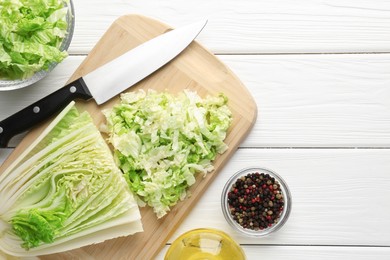 Photo of Cut Chinese cabbage and knife on white wooden table, flat lay. Space for text