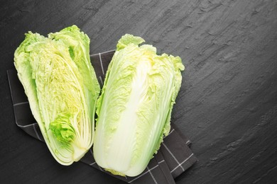 Photo of Chinese cabbages on black table, top view. Space for text