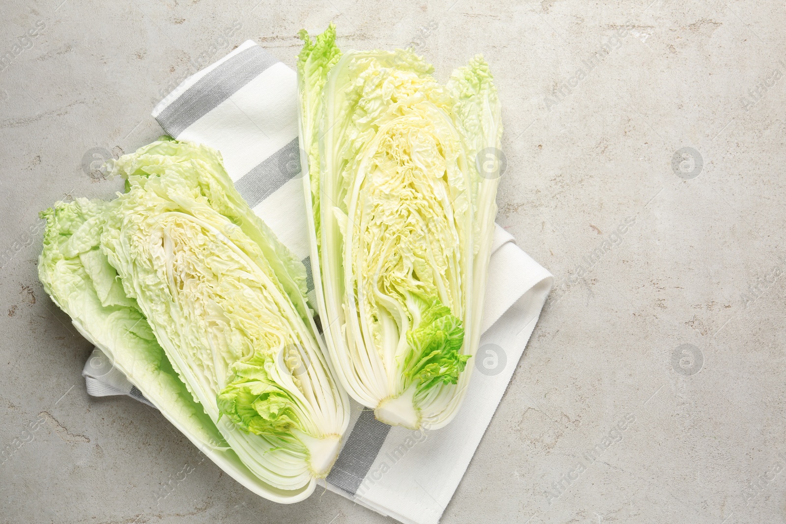 Cut Chinese cabbage on light grey table, top view. Space for text Photo of Cut Chinese cabbage on light grey table, top view. Space for text