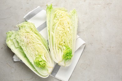 Photo of Cut Chinese cabbage on light grey table, top view. Space for text