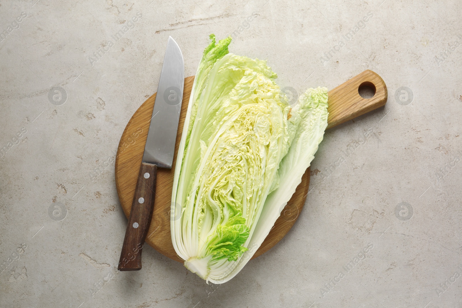 Cut Chinese cabbage and knife on light grey table, top view Photo of Cut Chinese cabbage and knife on light grey table, top view