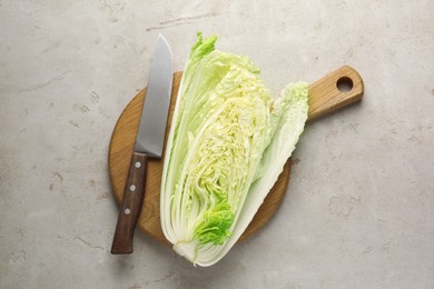 Photo of Cut Chinese cabbage and knife on light grey table, top view