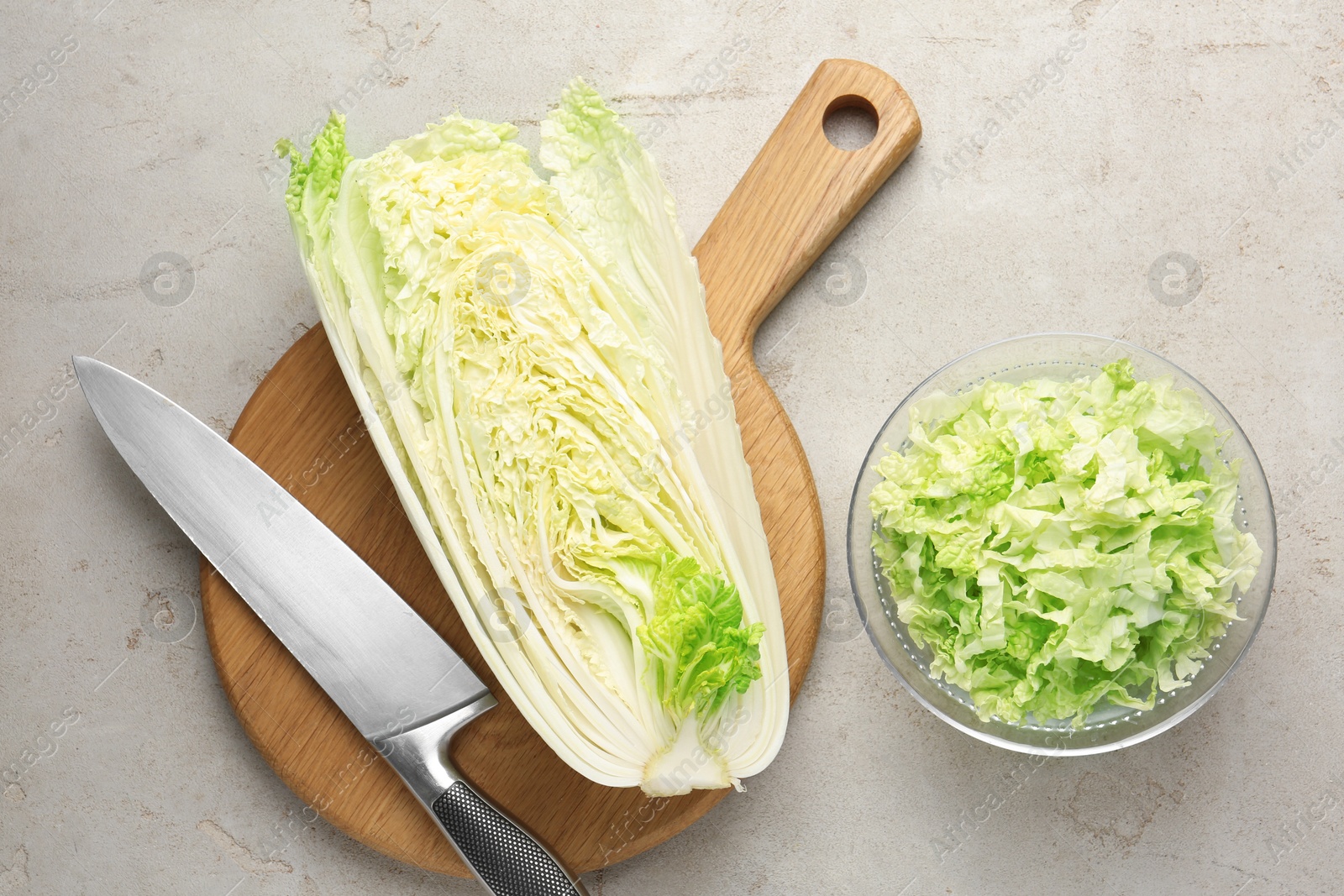 Cut Chinese cabbage and knife on light grey table, top view Photo of Cut Chinese cabbage and knife on light grey table, top view