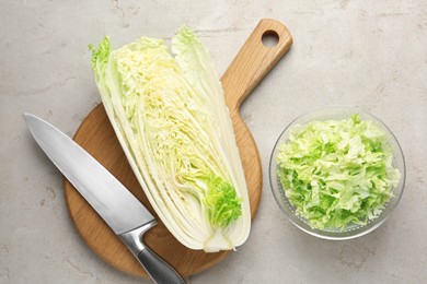 Photo of Cut Chinese cabbage and knife on light grey table, top view