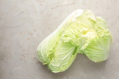 Photo of Fresh Chinese cabbages on light grey table, top view. Space for text