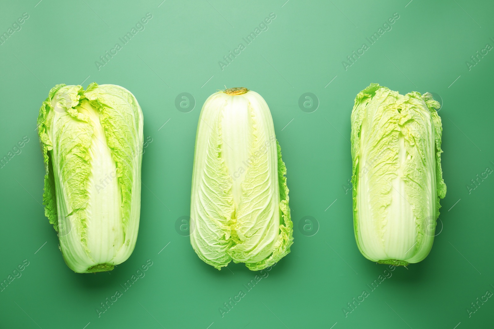 Fresh Chinese cabbages on green background, flat lay Photo of Fresh Chinese cabbages on green background, flat lay