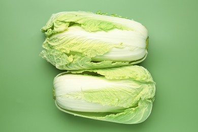 Photo of Fresh Chinese cabbages on green background, top view